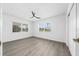 Bright bedroom features two windows and neutral walls and grey wood-look flooring at 520 Baywood S Dr, Dunedin, FL 34698