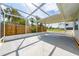 Spacious screened patio with high ceilings, perfect for entertaining or relaxing outdoors with views of the fenced backyard at 520 Baywood S Dr, Dunedin, FL 34698