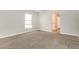 Neutral bedroom featuring plush carpet, a window, and an arched doorway at 13516 Copper Head Dr, Riverview, FL 33569