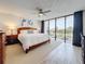 Bedroom with balcony access, ceiling fan, and wood furniture at 1581 Gulf Blvd # 102N, Clearwater Beach, FL 33767