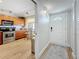 Well-lit kitchen featuring stainless steel appliances and wood cabinetry, adjacent to a dining area and entryway at 1581 Gulf Blvd # 102N, Clearwater Beach, FL 33767