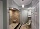 Bathroom featuring a tiled shower with a seat, decorative chandelier, and white fixtures at 200 4Th S Ave # 231, St Petersburg, FL 33701