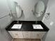 Bathroom vanity featuring white cabinets, dual sinks and mirrors at 200 4Th S Ave # 231, St Petersburg, FL 33701