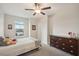 Cozy bedroom featuring a bed, dresser, ceiling fan, and a window with a neighborhood view at 8364 Capstone Ranch Dr, New Port Richey, FL 34655