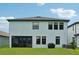 Back exterior view of home showcases screened in patio and nicely manicured backyard at 8364 Capstone Ranch Dr, New Port Richey, FL 34655