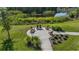 A round outdoor patio with Adirondack chairs overlooks serene pond and landscaping at 8364 Capstone Ranch Dr, New Port Richey, FL 34655