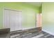 This empty bedroom features stylish flooring, white trim and bright green walls at 1647 Stable Trl, Palm Harbor, FL 34685