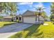 This single-story home features an attached two-car garage and landscaped front yard at 1647 Stable Trl, Palm Harbor, FL 34685