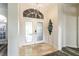 Bright foyer with travertine floors, a modern chandelier, and stylish front doors at 1647 Stable Trl, Palm Harbor, FL 34685