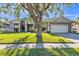 Charming single-story home featuring a manicured lawn and mature tree at 1647 Stable Trl, Palm Harbor, FL 34685