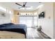 Relaxing main bedroom features a ceiling fan, transom windows, TV, and sliding glass door to an outdoor patio at 1647 Stable Trl, Palm Harbor, FL 34685