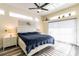 Spacious main bedroom with a ceiling fan, transom windows, a sliding glass door to a patio, and an ensuite bath at 1647 Stable Trl, Palm Harbor, FL 34685