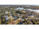 A scenic aerial shot of a two-story home on a lot near a pond and lush greenery at 7327 Brightwaters Ct, New Port Richey, FL 34652