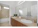 Bathroom featuring double sinks, wood cabinets, and a large mirror at 7327 Brightwaters Ct, New Port Richey, FL 34652