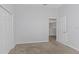 Neutral bedroom featuring carpeted floors, gray walls, closet, and an open door at 7327 Brightwaters Ct, New Port Richey, FL 34652