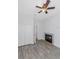 Bright bedroom features a ceiling fan, wood floors, and a charming fireplace with decorative tiles at 7327 Brightwaters Ct, New Port Richey, FL 34652