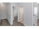 A hallway featuring grey carpet and doors leading to bedrooms and other areas of the house at 7327 Brightwaters Ct, New Port Richey, FL 34652