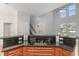 A kitchen island boasts an electric stovetop with dark countertops and natural light from the tall windows at 7327 Brightwaters Ct, New Port Richey, FL 34652