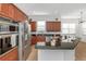 Modern kitchen featuring stainless steel appliances, dark wood cabinets, and a center island at 7327 Brightwaters Ct, New Port Richey, FL 34652
