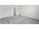 A bright bedroom featuring plush neutral carpet, fresh white walls, and a doorway to another room at 11905 Sylvia St, Dade City, FL 33525