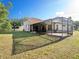 Wide view of the backyard highlighting the home's screened lanai and ample outdoor space for recreation and enjoyment at 12402 Creek Edge Dr, Riverview, FL 33579