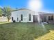 Lush backyard featuring the property's well-kept lawn, arched windows, and screened-in lanai, a perfect oasis at 12402 Creek Edge Dr, Riverview, FL 33579