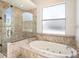 This bathroom features a luxurious soaking tub and a glass-enclosed shower at 12402 Creek Edge Dr, Riverview, FL 33579