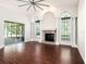 Spacious living room with wood floors, white walls, a fireplace, and sliding doors to the lanai at 12402 Creek Edge Dr, Riverview, FL 33579