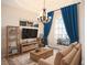 Cozy living room showcasing a large window with blue curtains, an area rug, and a decorative chandelier at 12402 Creek Edge Dr, Riverview, FL 33579