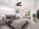 Serene main bedroom with tray ceilings, a ceiling fan, and ample natural light at 12402 Creek Edge Dr, Riverview, FL 33579