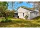 A beautiful outdoor view of the home showing a screened porch, large grassy yard, and mature trees at 1610 Spinning Wheel Dr, Lutz, FL 33559