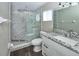 This main bath features updated lighting, marble shower, glass door, and a modern vanity at 1610 Spinning Wheel Dr, Lutz, FL 33559
