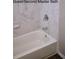 Bright bathroom featuring a white tub with tiled walls at 1610 Spinning Wheel Dr, Lutz, FL 33559