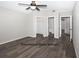 A spacious, gray bedroom featuring wood-look floors, ceiling fan, and access to closet and bathroom at 1610 Spinning Wheel Dr, Lutz, FL 33559