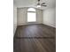 Guest bedroom features gray walls, wood flooring, natural light, and a ceiling fan at 1610 Spinning Wheel Dr, Lutz, FL 33559