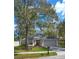 Exterior view of home featuring a two-car garage, a gray roof, gray siding, and a well-maintained yard at 1610 Spinning Wheel Dr, Lutz, FL 33559