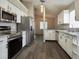 A kitchen featuring stainless steel appliances, white cabinets, and gray wood flooring at 1610 Spinning Wheel Dr, Lutz, FL 33559