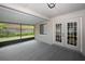 Spacious screened porch with carpet and views of the fenced backyard with a manicured lawn at 1610 Spinning Wheel Dr, Lutz, FL 33559