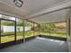 Spacious screened porch with carpet and views of the fenced backyard with a manicured lawn at 1610 Spinning Wheel Dr, Lutz, FL 33559