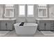 Luxurious bathroom featuring a freestanding tub, dual vanities, modern fixtures, and ample space at 32554 Silvercreek Way, Wesley Chapel, FL 33545