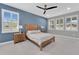 Inviting bedroom featuring blue accent wall, neutral-colored furnishings, and natural light from shuttered windows at 32554 Silvercreek Way, Wesley Chapel, FL 33545