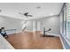 Spacious bonus room with hardwood floors, ceiling fan, and plenty of natural light from the shuttered windows at 32554 Silvercreek Way, Wesley Chapel, FL 33545