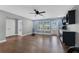 Bonus room featuring hardwood floors, wet bar with marble counters, a ceiling fan, and access to other areas at 32554 Silvercreek Way, Wesley Chapel, FL 33545