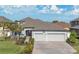 Charming single-Gathering home featuring a three-car garage, brick driveway, and manicured landscaping at 32554 Silvercreek Way, Wesley Chapel, FL 33545