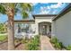 A charming front entrance with a brick walkway, tasteful landscaping, and a welcoming covered doorway at 32554 Silvercreek Way, Wesley Chapel, FL 33545