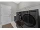 Modern laundry room equipped with high-end washer and dryer units at 32554 Silvercreek Way, Wesley Chapel, FL 33545