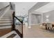 Bright living room featuring wood floors, staircase, and an open layout to the kitchen and dining areas at 32554 Silvercreek Way, Wesley Chapel, FL 33545