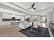 Open-concept living room with sleek finishes and an adjacent white kitchen with stainless steel appliances at 32554 Silvercreek Way, Wesley Chapel, FL 33545