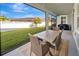 Screened patio with outdoor dining set overlooking a beautifully maintained backyard at 32554 Silvercreek Way, Wesley Chapel, FL 33545