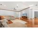 Open-concept living room boasts hardwood floors, ceiling fan, and a cozy sectional sofa at 10809 Cedar Cove Drive, Thonotosassa, FL 33592